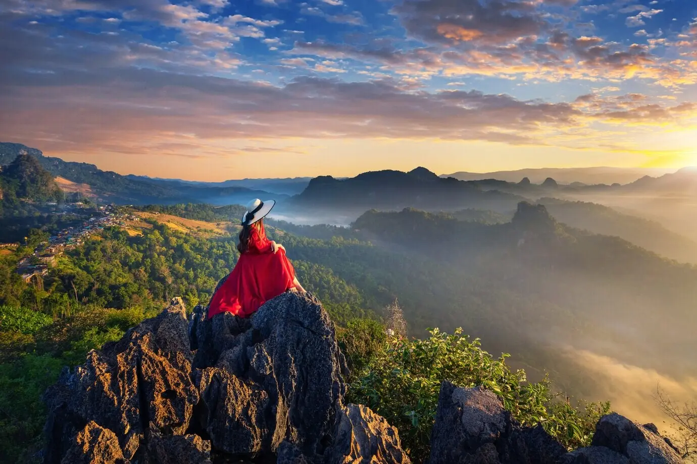 A beautiful girl sits at the sunrise viewpoint in Ja Bo village, Mae Hong Son Province, Thailand.